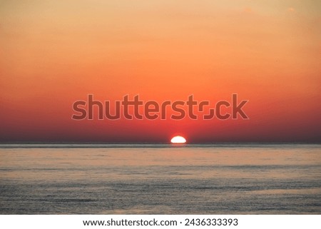 Watching dramatic sunset at coastal village Funtana, Istria, Croatia, EU. Calm sea surface reflects vibrant colors of sky. Vacation at Adriatic Mediterranean Sea. Romantic specular reflection. Sparkle