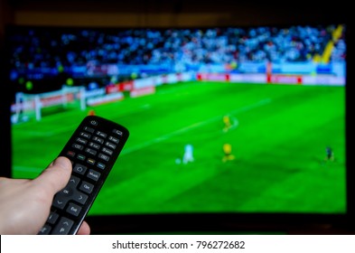 Watching Football On TV And Using Remote Controller.