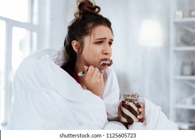 Watching Melodrama. Woman Feeling Emotional While Watching Melodrama And Eating Chocolate Spread With Spoon