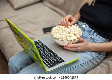 watching a movie with popcorn and a laptop on your lap - Shutterstock ID 2148342879