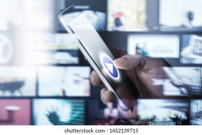 Watching movies and series with smartphone. On demand (VOD) service. Future multimedia technology in mobile phone. Man pressing play button. Entertainment of tv network. Many online video thumbnails. - Powered by Shutterstock