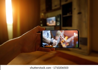 Watching Online Music Concert At Home Using A Mobile Phone. Guitar Close-up On The Screen