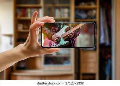 Watching Online Music Concert At Home Using A Mobile Phone. Guitar Close-up On The Screen