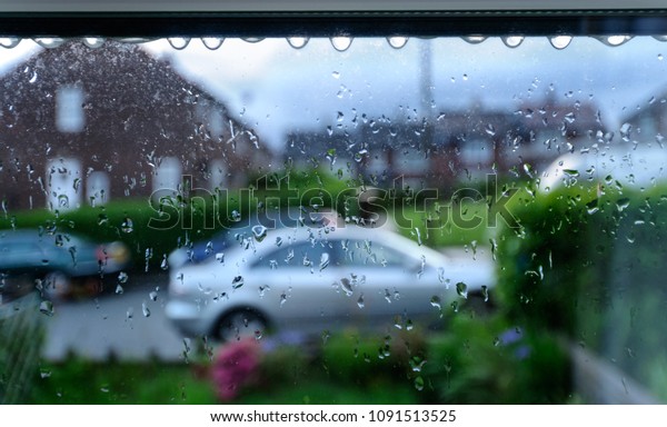Watching rain through a home\
window