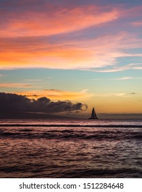 Watching A Sail Boat During A Colorful Sunset In Maui