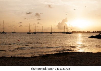 Watching Sailboats Cross The Horizon In The Caribbean At Sunset.