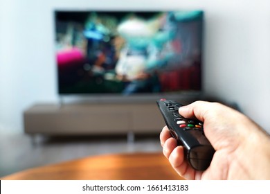 Watching Smart TV And Changing Channels With Remote Control.