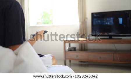 Watching smart  TV and using remote controller Hand holding television  audio remote control  with the remote control television