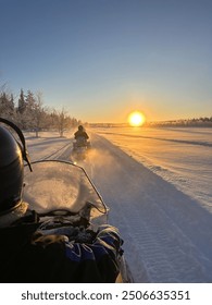 Watching the sunrise whilst on a snowmobile safari in Finnish Lapland.