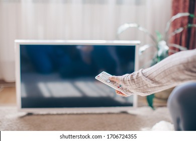 Watching TV. A Woman's Hand Holding The TV Remote Control With A Television In The Background. Nature, Documentary, Tv Screen, Binge Watching. Home Concept. Woman Hand. Concept. 
