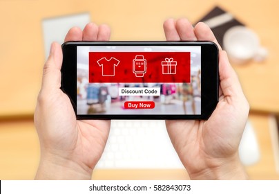 Watching Two Hand Holding Mobile Phone With Online Shopping Store And Discount Code On Screen With Blur Desk Office Background,Digital Lifestyle Concept.