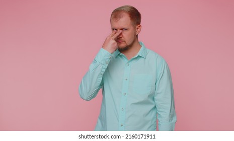 I Am Watching You. Man 30s In Blue Shirt Pointing At His Eyes And Camera, Show I Am Watching You Gesture, Spying On Someone. Young Adult Blonde Guy Boy Isolated Alone On Pink Studio Wall Background