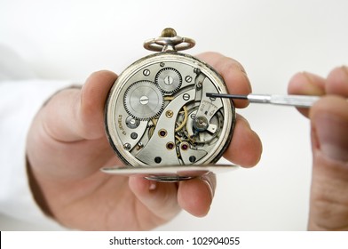 Watchmaker holding antique pocket watch show the clockwork mechanism and repair with screwdriver.
