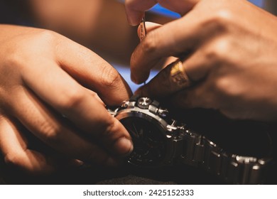 Watchmaker using spring bar tool. Spring bar tool used to remove spring bars to change watch strap.