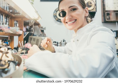 Watchmaker Woman Looking At Camera In Her Workshop