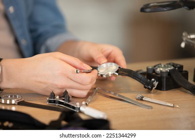 watchmaker in workshop repairing a wrist watch - Powered by Shutterstock