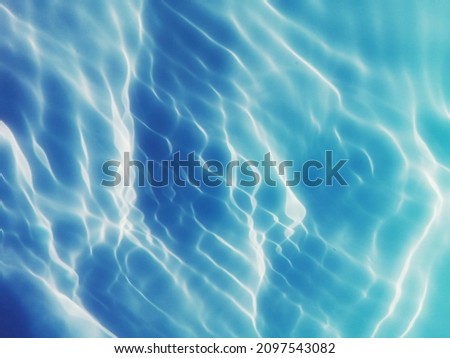 Closeup​ blur​ abstract​ of​ surface​ blue​ water. Abstract​ of​ surface​ blue​ water​ reflected​ with​ sunlight​ for​ background.Top​ view​ of blue​ water.​ Water​ splashed​ use​ for​ background.