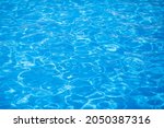 Water background, ripple and flow with waves. Summer blue swiming pool pattern. Sea, ocean surface. Overhead top view with place for text.