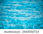 Water background, ripple waves. Blue swiming pool pattern. Sea surface. Water in swimming pool with sun reflection. Banner with copy space.