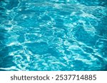 Water background, ripple waves. Blue swiming pool pattern. Sea surface. Water in swimming pool with sun reflection. Banner with copy space.