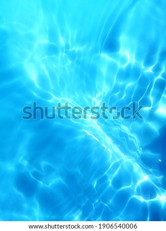 Blur​ abstract​ of​ surface​ blue​ water. Abstract​ of​ surface​ blue​ water​ reflected​ with​ sunlight​ for​ background. Blue​ sea. Blue​ water.​ Water​ splashed​ use​ for​ graphic​ design. Water