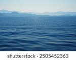 Water background texture. Sea surface in sunset light. Breezy wavy seawater. Sea water texture. Teal blue ocean view. Fresh water of lake. Relaxing natural photo wallpaper. calm sea surface