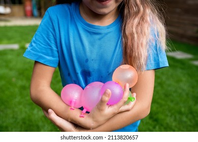 Water Balloon Games For Kids. Smiling Child Girl Holding Colorful Balls Filled With Water. Ready To Fight! Summer Fun Outdoor Activities For Children Concept