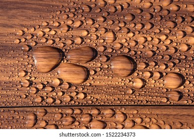 Water beads on a wooden surface