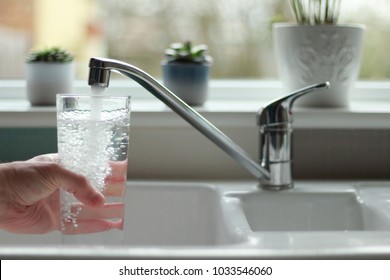 Water Being Poured Into Glass From Kitchen Tap