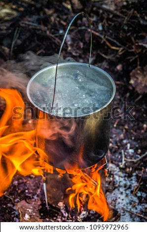 Water boiling in a camping pot on a folding hiking stove