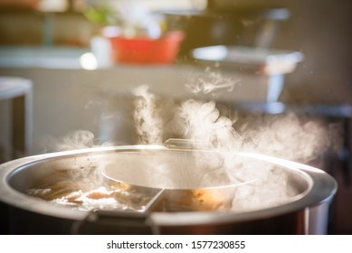 The Water Is Boiling In A Large Soup Pot, There Is Smoke And Hot Spit.