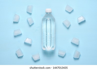 Water Bottle And Ice Pieces On Blue Table Top View