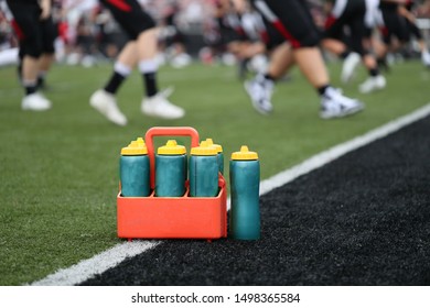 Water Bottles Are On The Field As High School Football Players Warm Up.