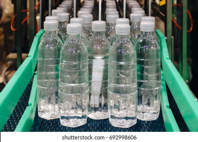 Water Bottling In The Transparent Plastic Bottles At The Factory Line Of The Filling Machine At The Beverage Manufacturing.