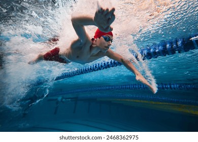 Water bubbles demonstrating speed. Young man, swimming athlete in motion in pool training, preparing for competition. Concept of professional sport, health, endurance, strength, active lifestyle - Powered by Shutterstock