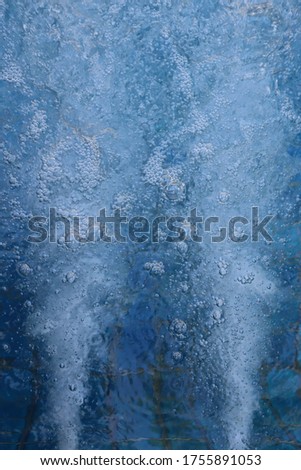 Water and bubbles, that were ejected from the Jacuzzi, on blue background