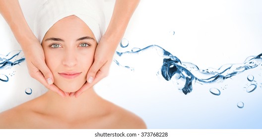 Water bubbling on white surface against attractive woman receiving facial massage at spa center