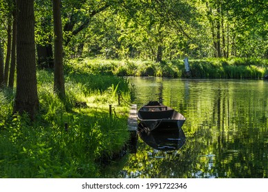 Water canal with old boat in the biosphere reserve Spree forest (Spreewald) in the state of Brandenburg, Germany, in springtime. - Shutterstock ID 1991722346