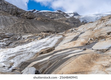 Water cascades down the rocky landscape near Schlaten Glacier, showcasing the stunning contrast of the rushing stream against the rugged terrain. This glacial area reflects beauty of Austrian Alps - Powered by Shutterstock