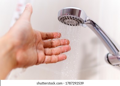 Water Close Up Background. Close-up Of A Man Hand Check Water Temperature In The Shower With Hand Shower