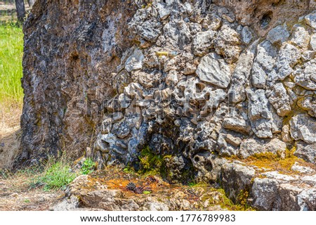 WATER COMING OUT OF AN OLD FAUCET INLAYED IN THE ROCK IN A MOUNTAIN ON A HOT SUMMER MORNING