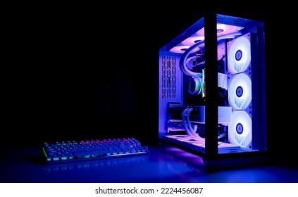 Water Cooled Gaming Pc with RGB rainbow LED lighting. Modern gaming computer with a keyboard in a dark room. Water Liquid Cooling Computer - Shutterstock ID 2224456087