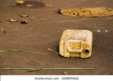 Water Crisis In Uganda, An Old Yellow Water Container Laying On The Ground After Being Used To Fetch Contaminated Drinking Water From The Next Puddle