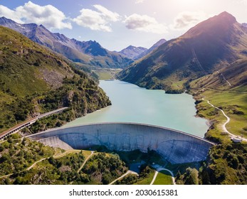 Water dam and reservoir lake in Swiss Alps generating hydroelectricity. Aerial view of arch dam between mountains. Hydropower green energy for sustainable development against global warming. Zero CO2