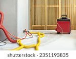 Water damage restoration service in a leaking home with industrial air movers, dehumidifiers and pipes to remove the water and moist from the wet floor and repair the house. Household insurance