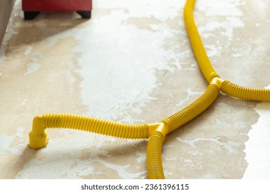 Water damage restoration service pipes in a leaking home environment connected to industrial air movers and dehumidifiers to remove the water and moist from the wet floor. Household insurance