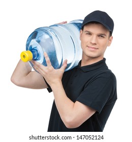 Water delivery. Cheerful young deliveryman holding a water jug while isolated on white