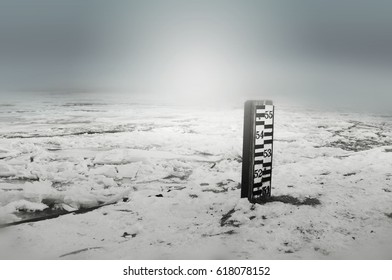 Water Depth Meter In Winter Period. White, Winter Light On Blur Background