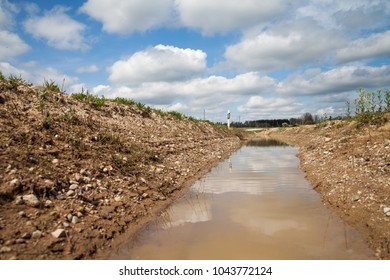 Water In Ditch At Gravel Road.