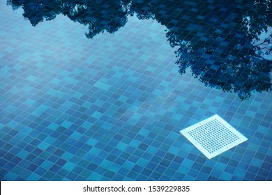 Water drain filter in a blue swimming pool, top view.                            